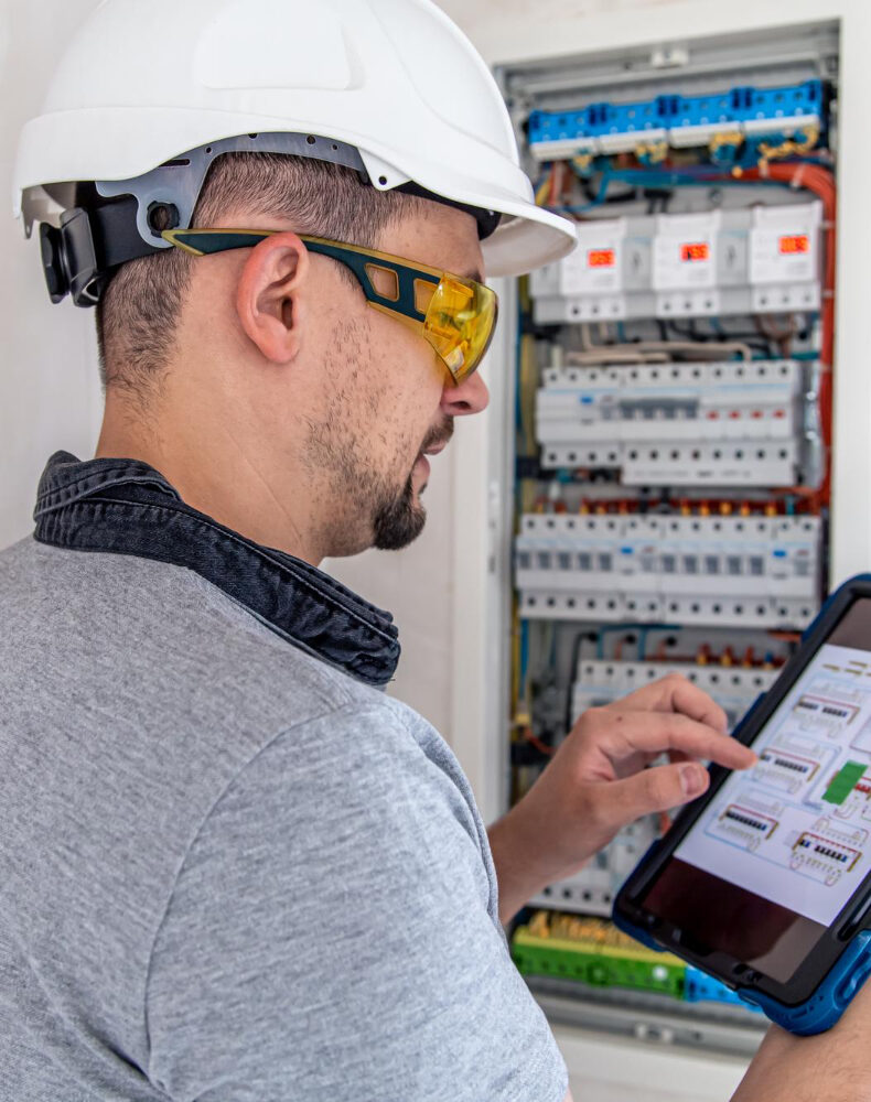 Elektryk, który stoi przy instalacji elektrycznej we Wrocławiu